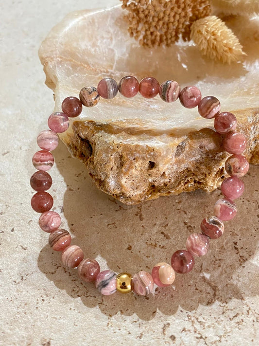 Bracelet perles rondes rhodochrosite rose et boule dorée sur pierre naturelle